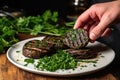 a person garnishing grilled portobello mushrooms with parsley