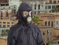 Person in gas mask against the backdrop of abandoned production