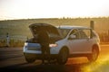 A person, gazing at a stranded car with a broken engine Royalty Free Stock Photo