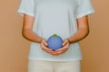 A person gently holds a small, blue sphere with a tiny sprout, symbolizing environmental care and growth Royalty Free Stock Photo