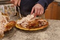 Person getting ready roasted turkey on plate on kitchen table. Thanksgiving dinner Royalty Free Stock Photo