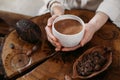 Person giving ceremonial cacao in cup. chocolate drink top view Royalty Free Stock Photo