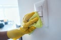 Person With Gloves Disinfecting Light Switches Using Sanitizer Royalty Free Stock Photo