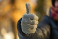 person in gloves giving a thumbsup to the camera