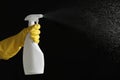 Person in gloves spraying detergent on background, closeup. Space for text