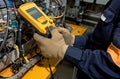 Person in gloves using electronic multimeter in electrical system, electrical inspection picture