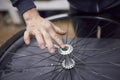 Person greasing the hub of a bicycle wheel while maintenance service