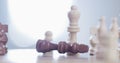 Person, hand and chess piece in defeat on board for king, checkmate or endgame on table at home. Closeup of people