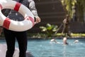 Person hand holding ringbuoy to rescue drowning in dangerous situation on summer vacation,asian child girl struggling in water,