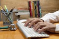 Person with hand on keyboard at an office desk