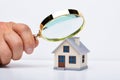 Person Hand With Magnifying Glass And Miniature House