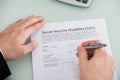 Person Hand Over Social Security Disability Claim Form