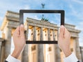 Person hand photographing brandenburg gate