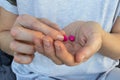 Person hand with pills. Woman holding two pink pills in hand. Healthcare, medicine concept. Patient take medicament, supplements, Royalty Free Stock Photo