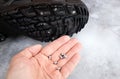 Person hand show self screws studs witch attach to winter boot sole.