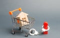 A person is handcuffed to a house on a supermarket cart. Financial dependence, unavailable housing for young families. Freeze of Royalty Free Stock Photo