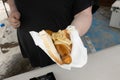 A person handing an Australian sausage in bread at a sausage sizzle