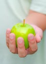 A person is handing green apple for you. Royalty Free Stock Photo