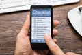 Person Hands Filling Checklist On Mobile Phone