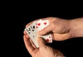 Person hands are holding playing cards three sixes close up on black background