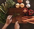 Person, hands and knife with vegetables, chopping board and food with ingredients and wellness. Closeup, utensils and Royalty Free Stock Photo