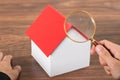Person hands with magnifying glass and model house Royalty Free Stock Photo