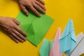 person hands making a origami color paper planes