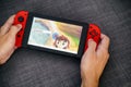 Person hands playing Super Mario Maker 2 video game on Nintendo Switch video game console