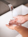 Person, hands and soap with water for hygiene, cleaning or germ and bacteria removal in bathroom at home. Closeup of tap Royalty Free Stock Photo