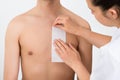 Person Hands Waxing Man's Chest