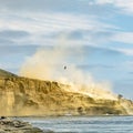 Person hanging on a helicopter over Sunset Cliffs