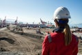 person in hard hat surveying port expansion area