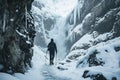 person hiking through a snow-covered mountain trail, with a frozen waterfall in the background