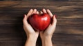 Hands forming heart around apple