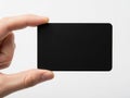 A person holding a black rectangular object in their hand against a white background Royalty Free Stock Photo