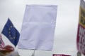 A person holding a blank protest banner at a political rally