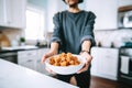 person holding a bowl of tempeh over a kitchen counter