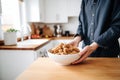 person holding a bowl of tempeh over a kitchen counter