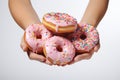A Person Holding A Bunch Of Doughnuts With Pink Frosting And Sprin