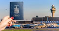 Person holding a Canadian passport with airport terminal background Royalty Free Stock Photo