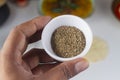 A person holding a celery seed bowl in hand on light background