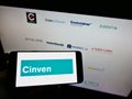 Person holding cellphone with company logo of British private equity firm Cinven Partners LLP on screen in front of webpage.