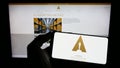 Person holding cellphone with logo of Academy of Motion Picture Arts and Sciences (AMPAS) on screen with web page.