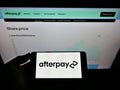 Person holding cellphone with logo of Australian fintech company Afterpay Limited on screen in front of website with chart. Royalty Free Stock Photo