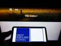 Person holding cellphone with logo of British property company Great Portland Estates plc on screen in front of webpage.