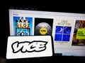 Person holding cellphone with logo of broadcasting company Vice Media LLC on screen in front of business webpage. Royalty Free Stock Photo