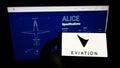 Person holding cellphone with logo of electric aircraft company Eviation Aircraft Ltd. on screen in front of website.