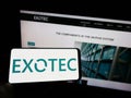 Person holding cellphone with logo of French logistics technology company Exotec SAS on screen in front of webpage.