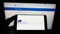 Person holding cellphone with logo of German solar energy company Blue Elephant Energy AG on screen in front of web page.