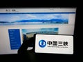 Person holding cellphone with logo of power company China Three Gorges Corporation (CTG) on screen in front of webpage.